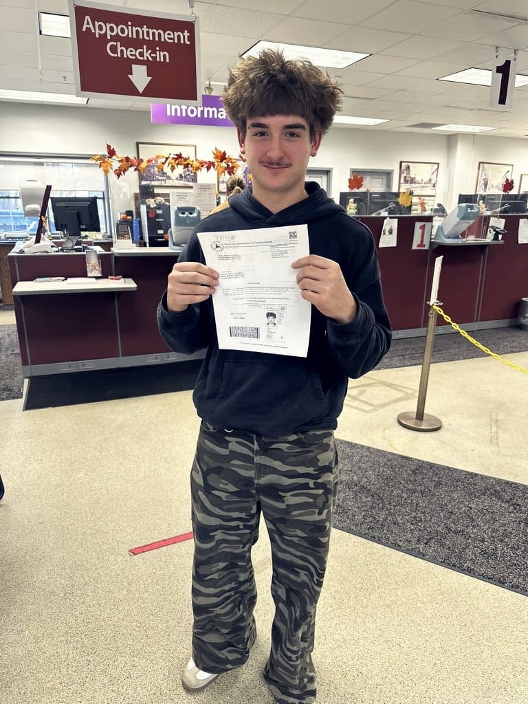 Colin holding his Wisconsin learner's permit at the DMV