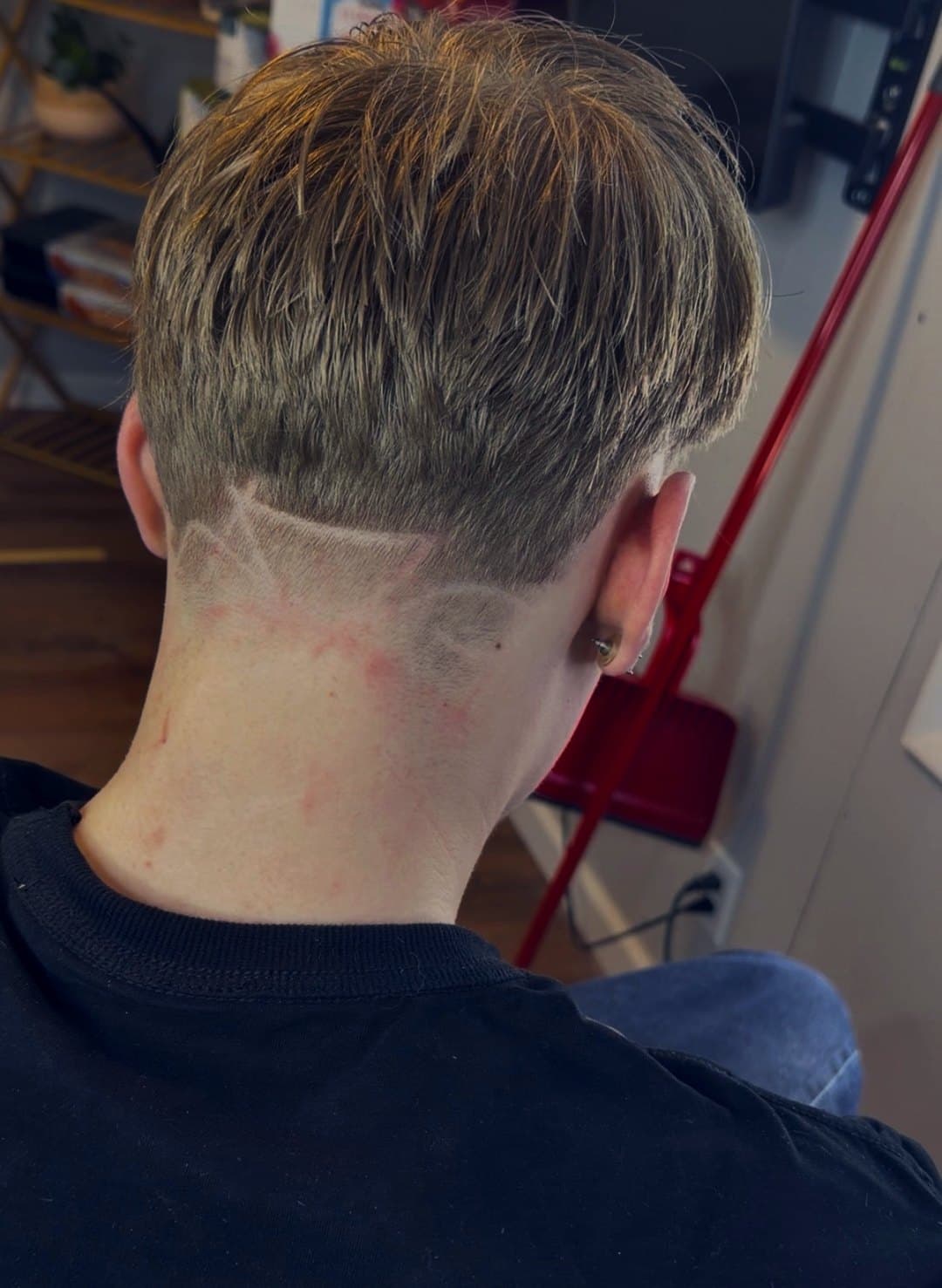 Custom hair design carved into a low fade, back view