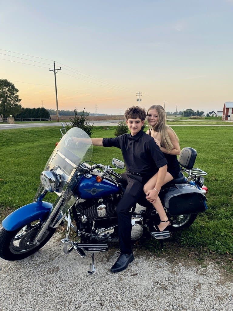 Colin in prom black on a blue Harley at sunset on a Wisconsin country road